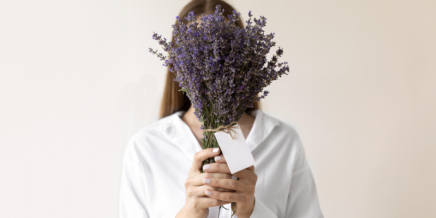 Femme qui tient dans ses mains un bouquet de lavande 